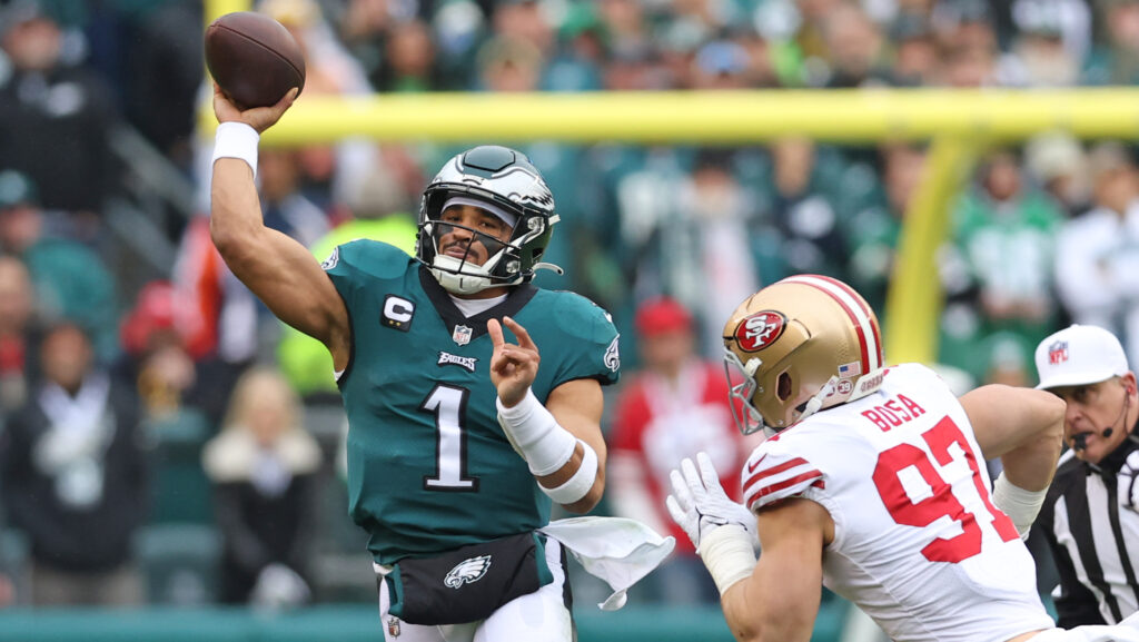 Philadelphia Eagles quarterback Jalen Hurts throws under pressure from San Francisco 49ers rusher Nick Bosa.