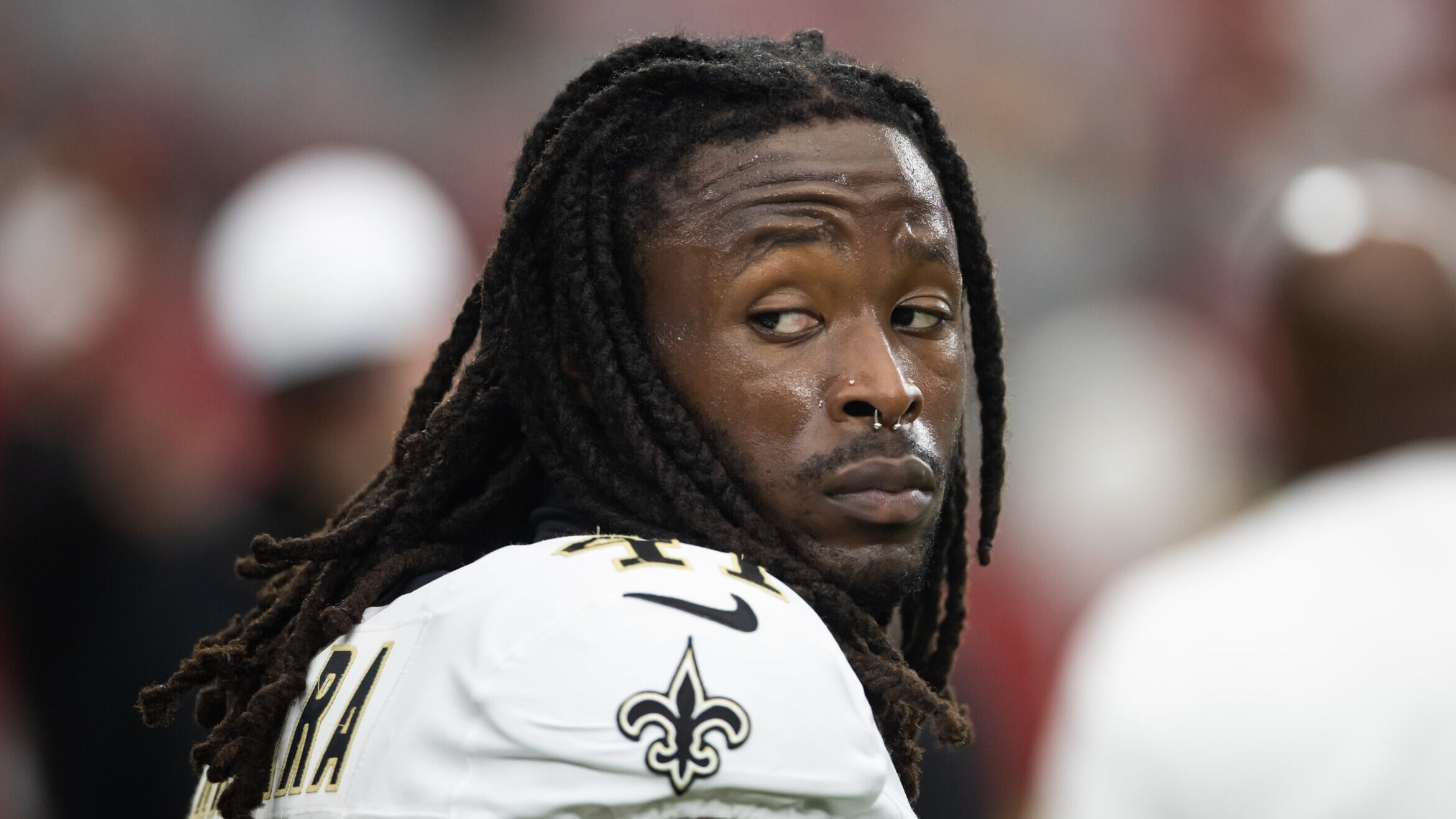 Alvin Kamara with his helmet off looks over his shoulder