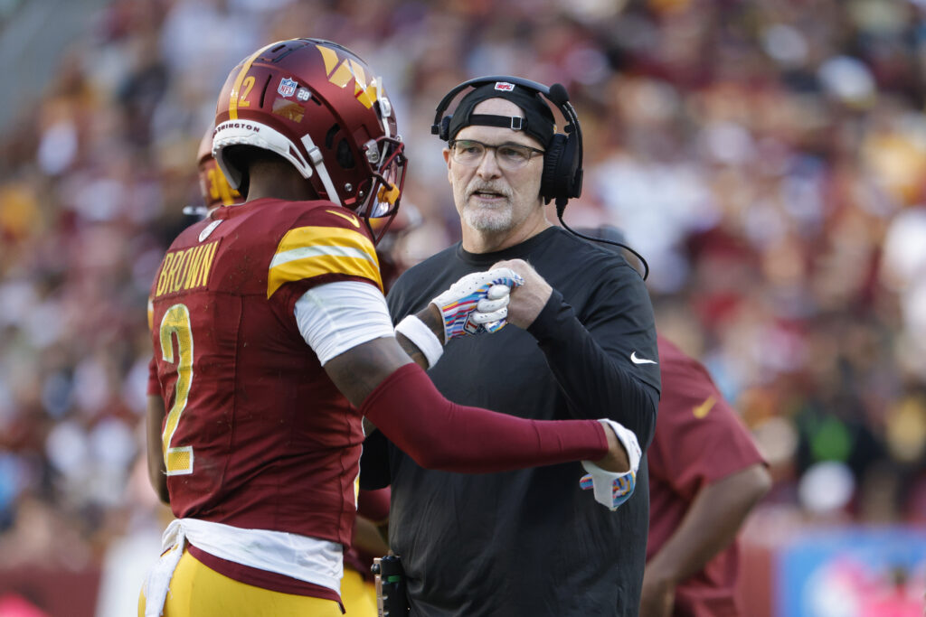 Washington Commanders head coach Dan Quinn fist bumping wide receiver Dyami Brown during the first quarter against the Carolina Panthers at Northwest Stadium in Landover, Maryland on October 20, 2024