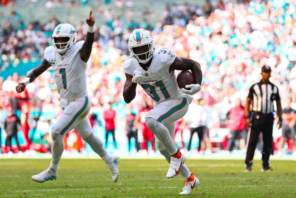 Miami Dolphins running back Raheem Mostert runs with the football for a touchdown as quarterback Tua Tagovailoa celebrates. 