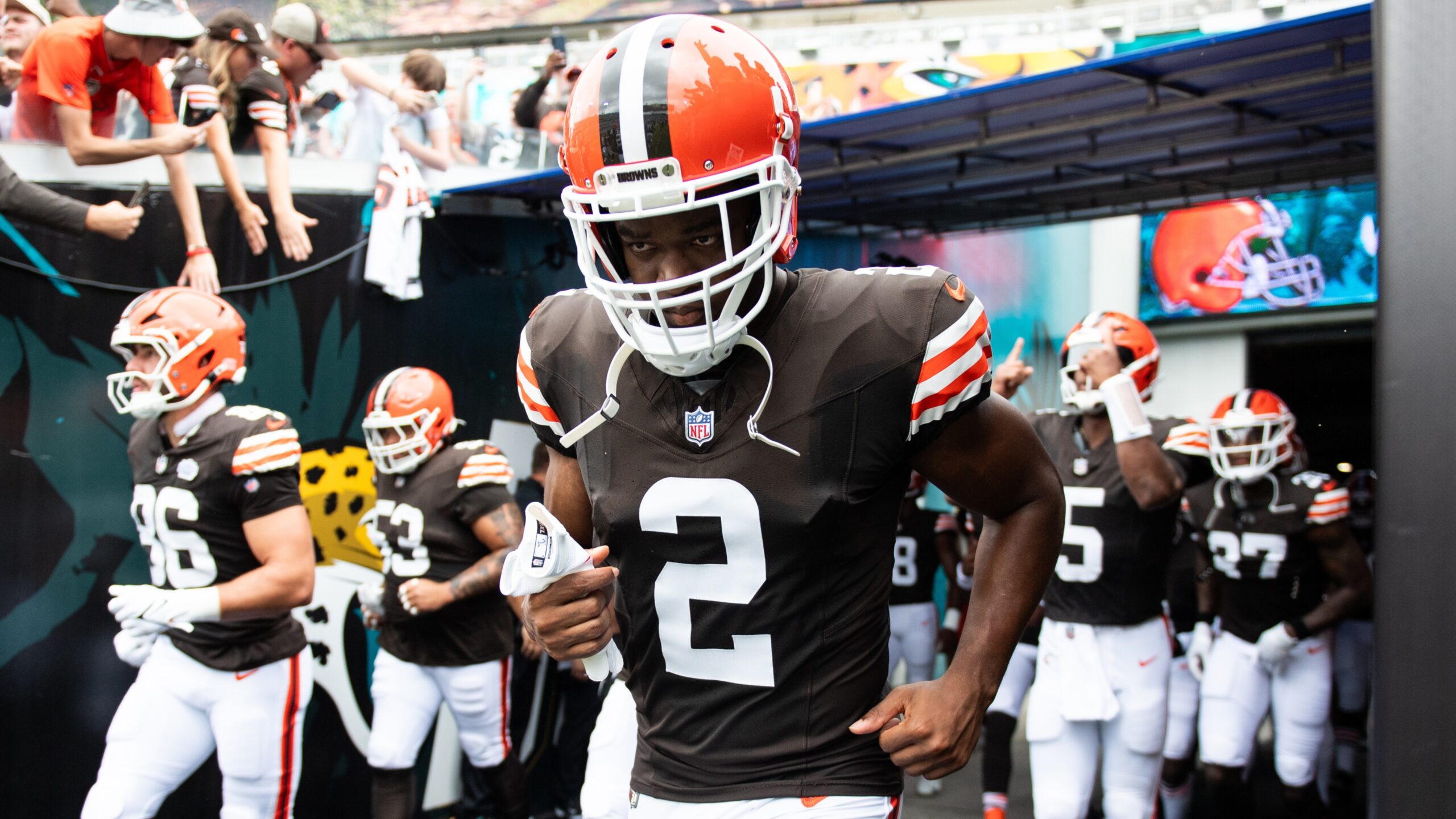 Amari Cooper runs out of the tunnel with his teammates behind him.