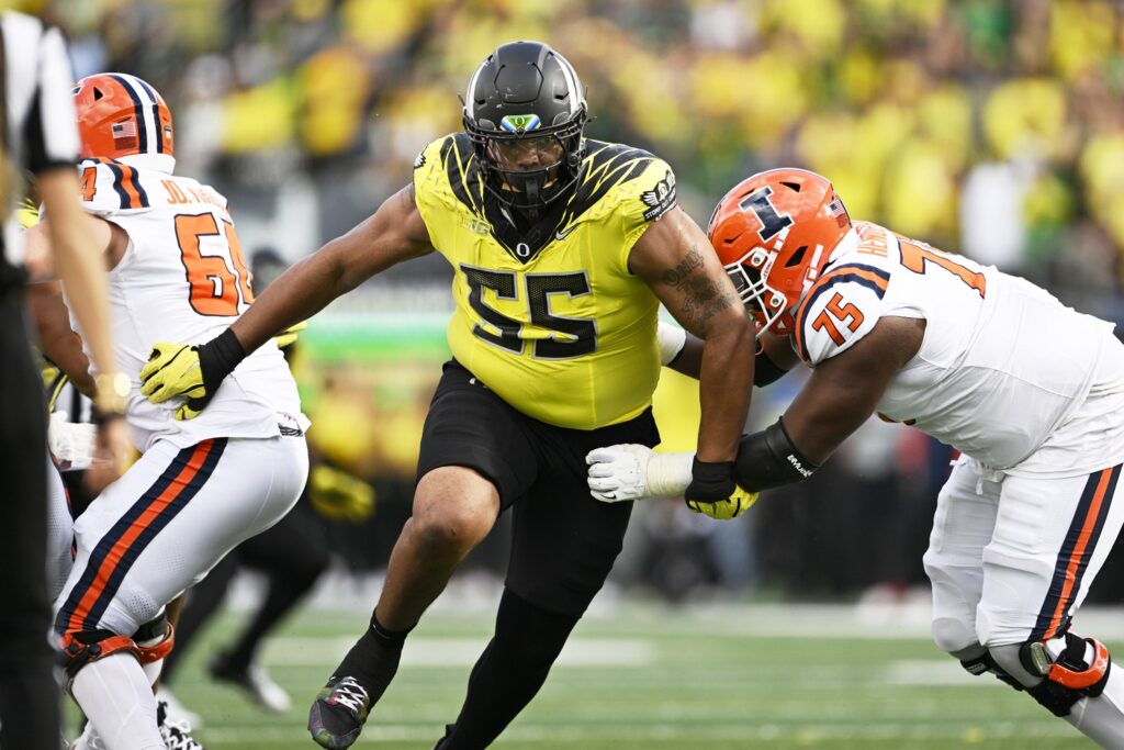 Oregon Ducks defensive lineman Derrick Harmon breaks past Illinois Fighting Illini offensive lineman Brandon Henderson in college football game action at Autzen Stadium