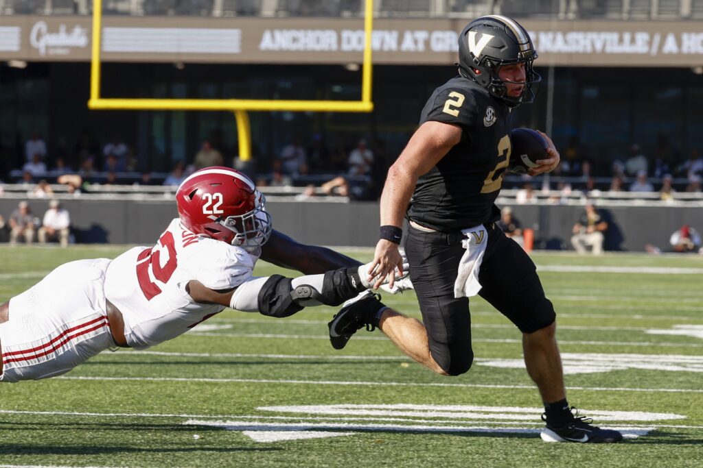 Vanderbilt Commodores quarterback Diego Pavia runs the ball against Alabama Crimson Tide defensive lineman LT Overton during college football game action at FirstBank Stadium