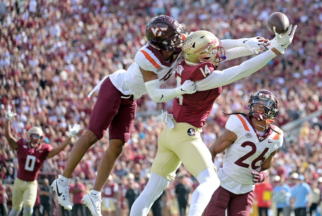 Florida State Seminoles wide receiver Keon Coleman attempts a catch as Virginia Tech Hokies cornerback Mansoor Delane defends during college football game action at Doak S. Campbell Stadium