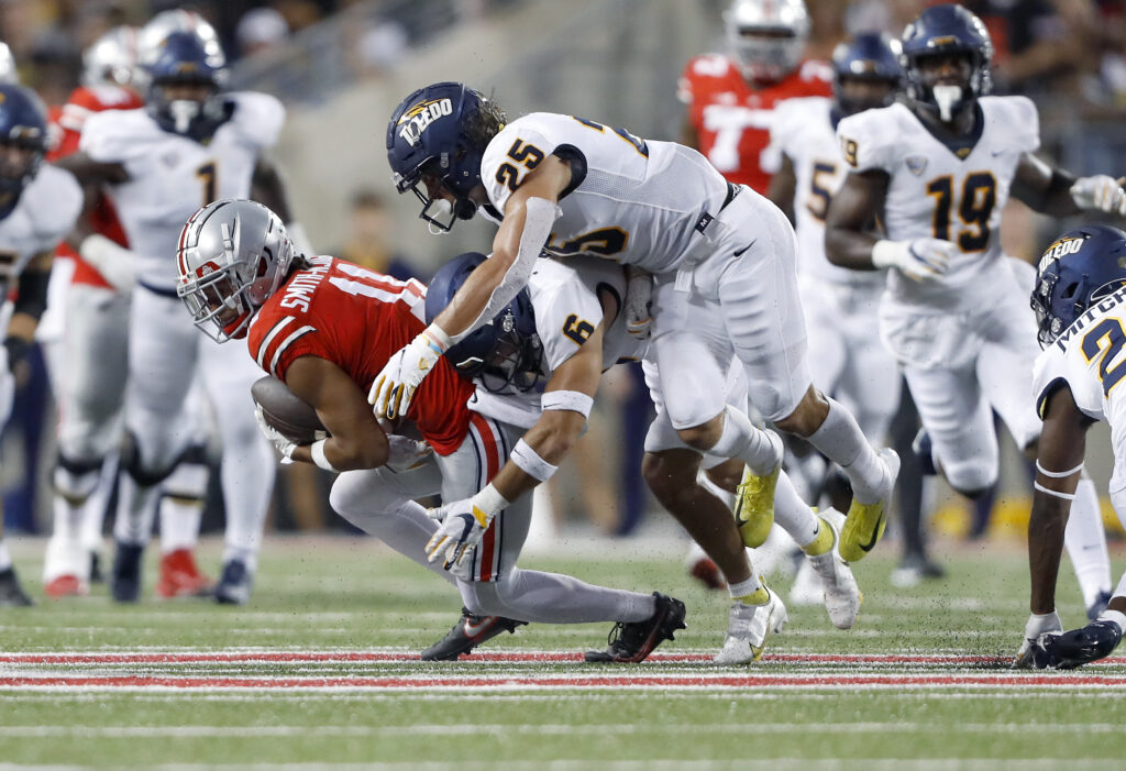 Ohio State Buckeyes wide receiver Jaxon Smith-Njigba (11) makes the catch as Toledo Rockets safety Nate Bauer (6) and safety Maxen Hook (25) make the tackle during the second quarter at Ohio Stadium.