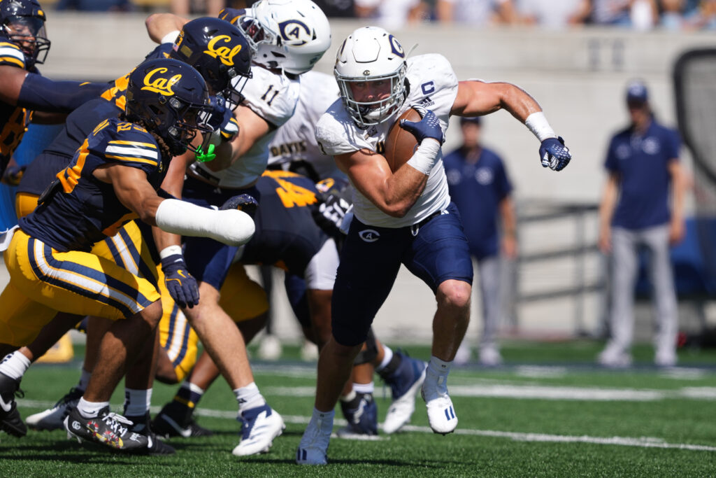 UC Davis Aggies running back Lan Larison (center) carries the ball against California Golden Bears defensive back Isaiah Crosby (left) during the second quarter at California Memorial Stadium.