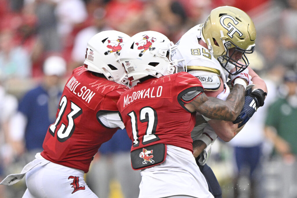 Georgia Tech Yellow Jackets tight end Jackson Hawes tries to break free from the tackles of Louisville Cardinals defensive backs. 