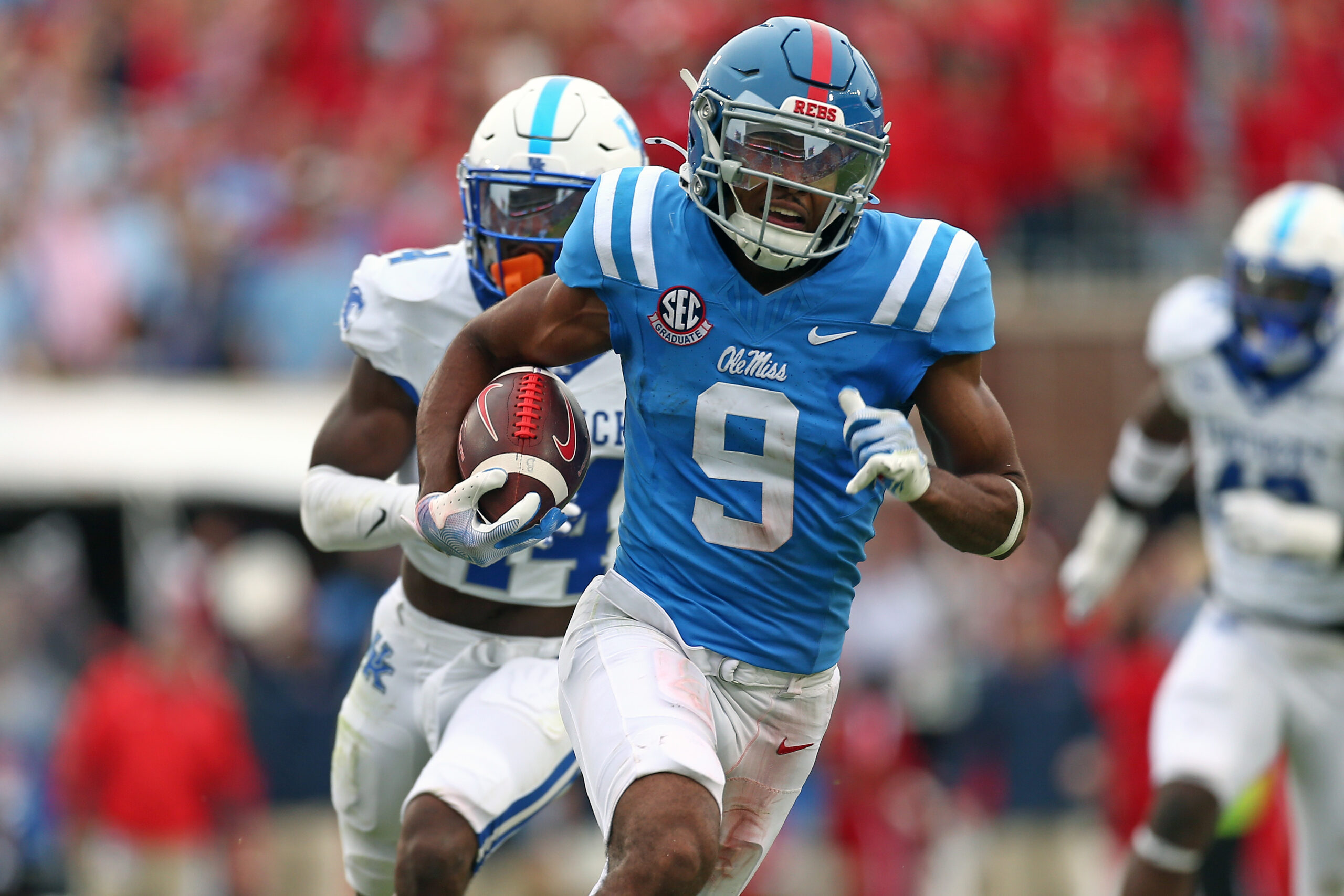 Mississippi Rebels wide receiver Tre Harris (9) runs after a catch for a first down as Kentucky Wildcats defensive back Jordan Lovett (25) pursues during the second half at Vaught-Hemingway Stadium.