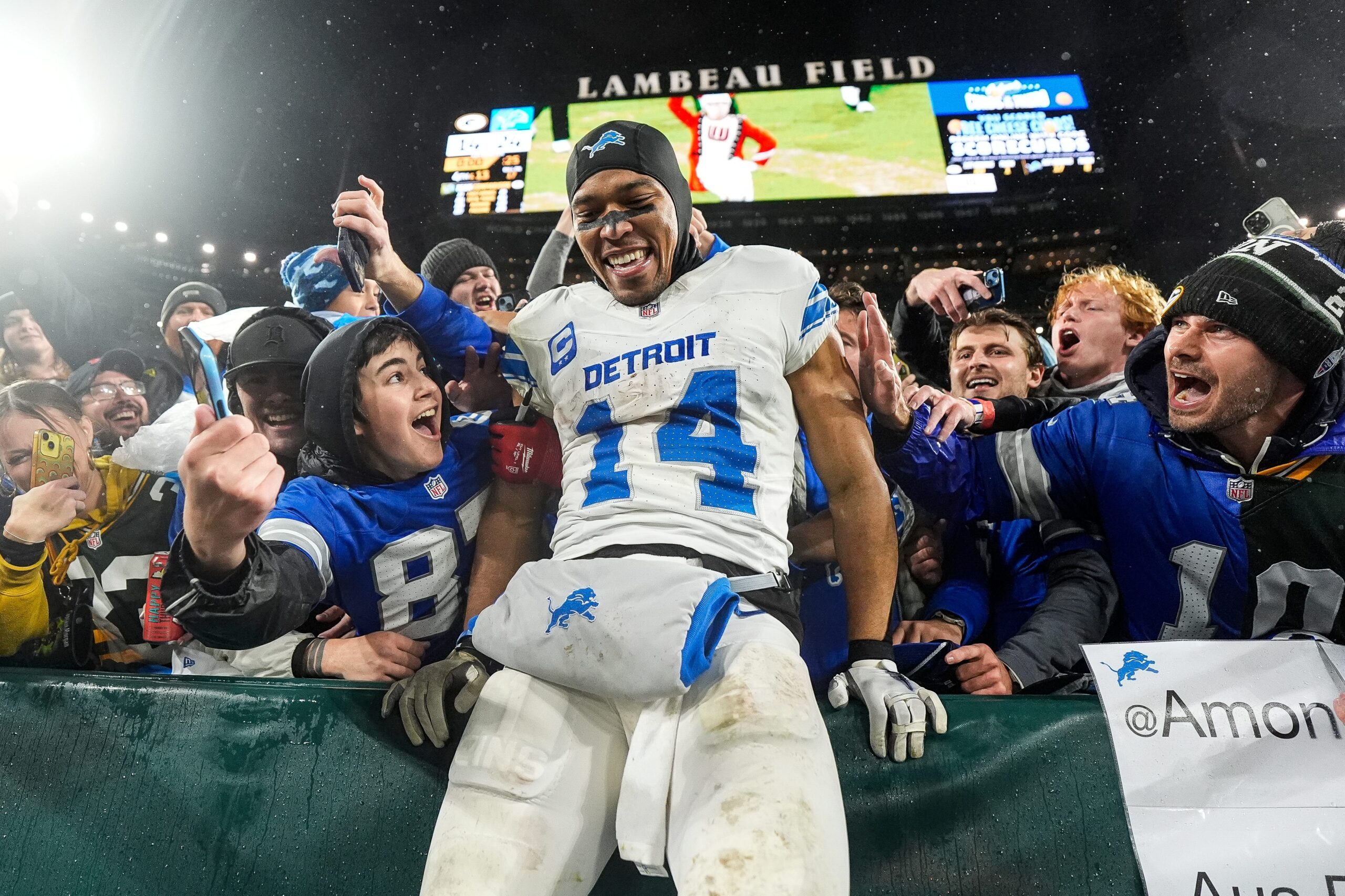 Detroit Lions wide receiver Amon-Ra St. Brown leaps into Lions fans as they celebrate 24-14 win over Green Bay Packers at Lambeau Field.