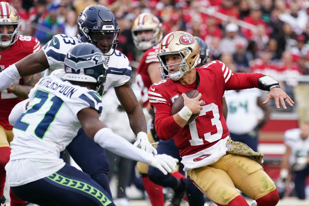 San Francisco 49ers quarterback Brock Purdy scrambles away from Seattle Seahawks cornerback Devon Witherspoon in the third quarter at Levi's Stadium.