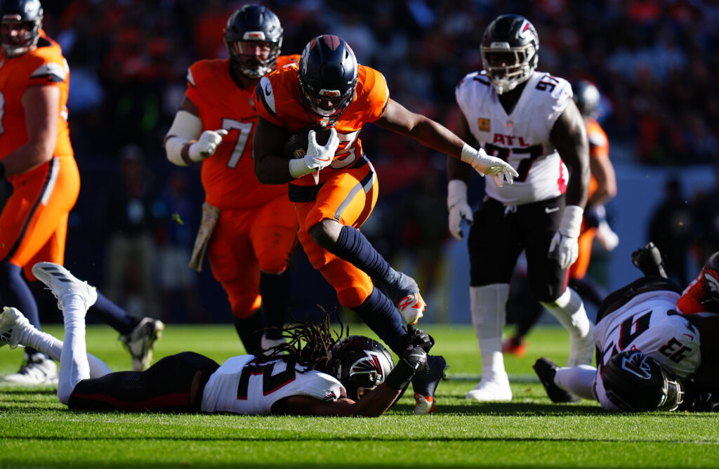 Denver Broncos running back Javonte Williams (33) carries the ball in the first quarter against the Atlanta Falcons at Empower Field at Mile High.