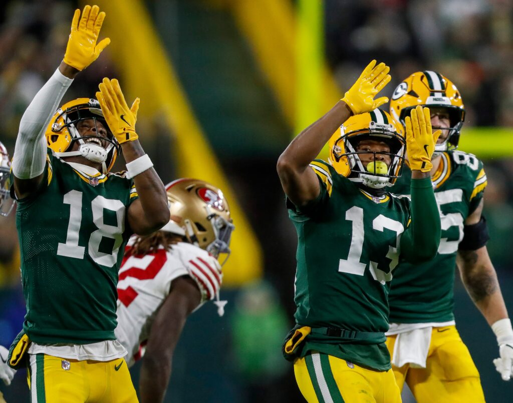 Green Bay Packers wide receivers Malik Heath (18) and Dontayvion Wicks (13) celebrate after Wicks makes a first down reception against the San Francisco 49ers on Sunday, November 24, 2024, at Lambeau Field in Green Bay, Wis. The Packers won the game, 38-10.