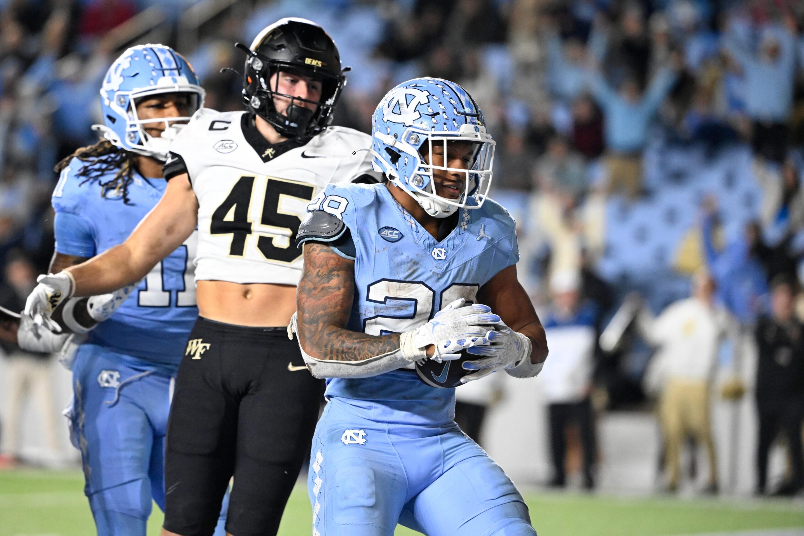 North Carolina Tar Heels running back Omarion Hampton (28) scores a touchdown as Wake Forest Demon Deacons defensive back Nick Andersen (45) defends in the fourth quarter at Kenan Memorial Stadium.