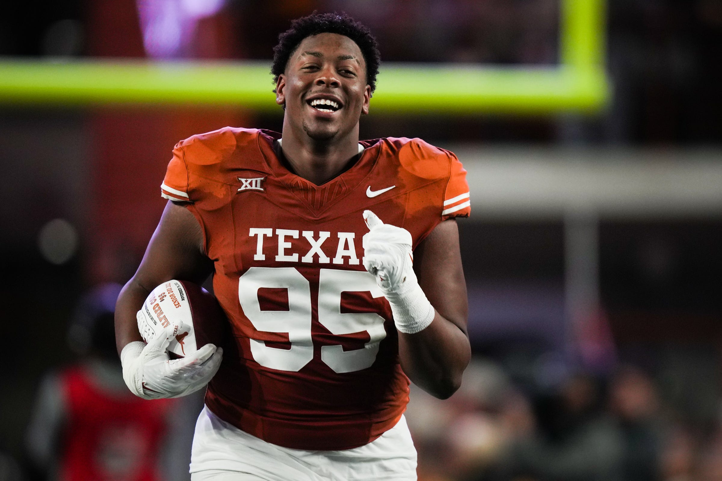 Texas defensive lineman Alfred Collins (95) runs down the field during the Senior Night celebration ahead the Longhorns' game against the Texas Tech Red Raiders.