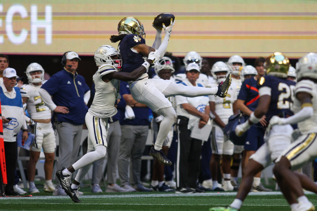 Notre Dame Fighting Irish safety Xavier Watts (0) intercepts a pass in front of Georgia Tech Yellow Jackets wide receiver Abdul Janneh Jr. (4) in the fourth quarter at Mercedes-Benz Stadium.