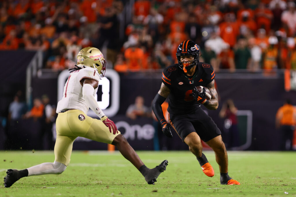 Miami Hurricanes tight end Elijah Arroyo (8) runs with the football against Florida State Seminoles defensive back Shyheim Brown (1) at Hard Rock Stadium.