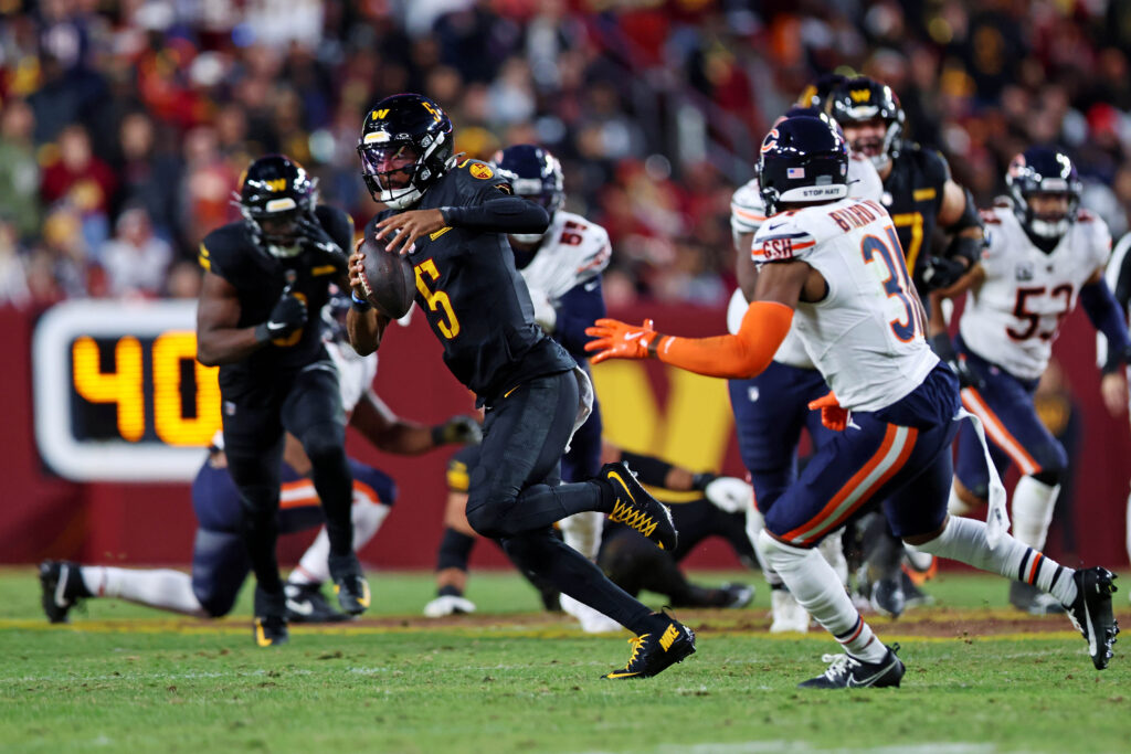 Washington Commanders quarterback Jayden Daniels (5) runs the ball against Chicago Bears safety Kevin Byard III (31) at Commanders Field.