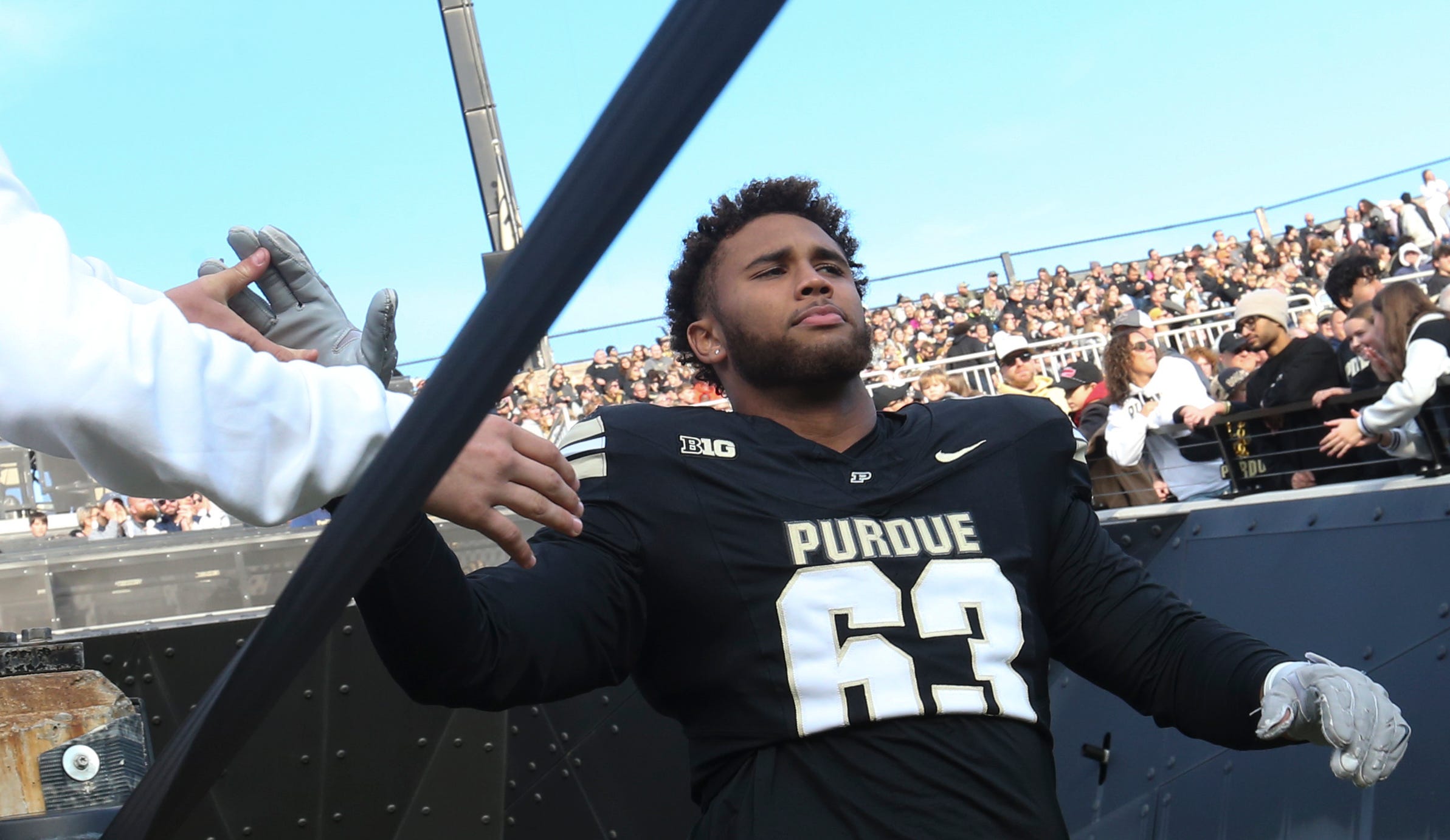 Purdue Boilermakers offensive lineman Marcus Mbow (63) high-fives a fan Saturday, Nov. 16, 2024, during the NCAA football game between the Purdue Boilermakers and the Penn State Nittany Lions at Ross-Ade Stadium in West Lafayette, Ind.