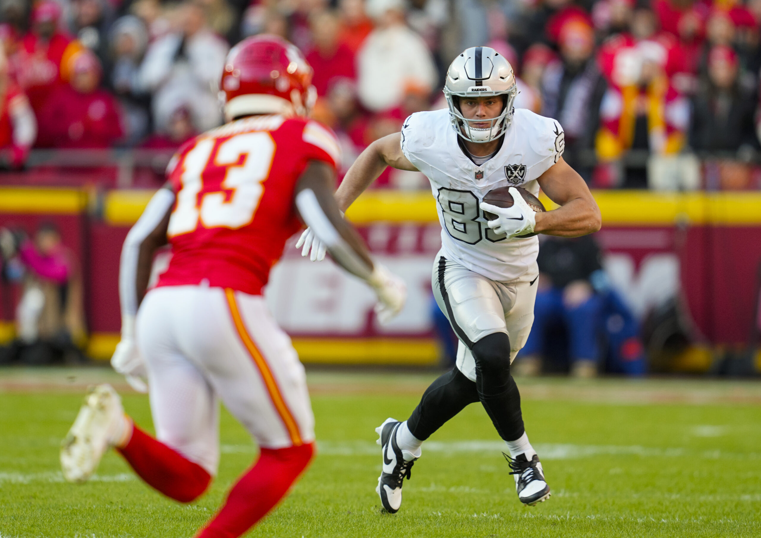 Las Vegas Raiders tight end Brock Bowers (89) runs with the ball against Kansas City Chiefs safety Nazeeh Johnson (13) during the first half at GEHA Field at Arrowhead Stadium.