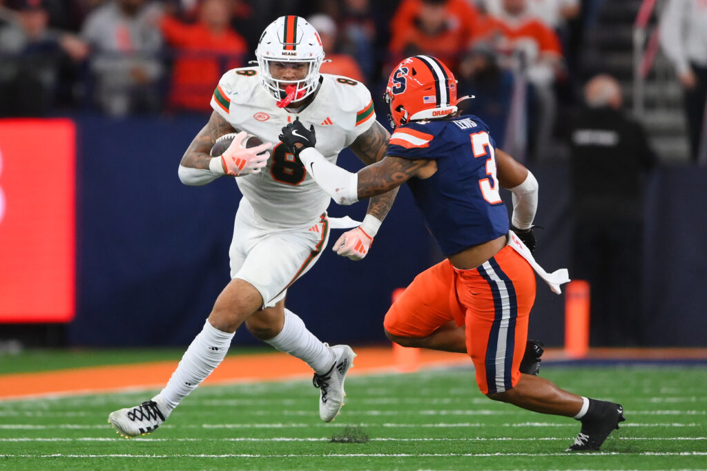 Miami Hurricanes tight end Elijah Arroyo (8) runs with the ball after a catch against Syracuse Orange defensive back Clarence Lewis (3) at the JMA Wireless Dome.