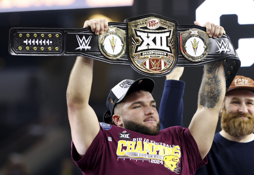 Arizona State Sun Devils running back Cam Skattebo (4) celebrates with the WWE Championship belt after being named the most outstanding player after the game against the Iowa State Cyclones at AT&T Stadium.