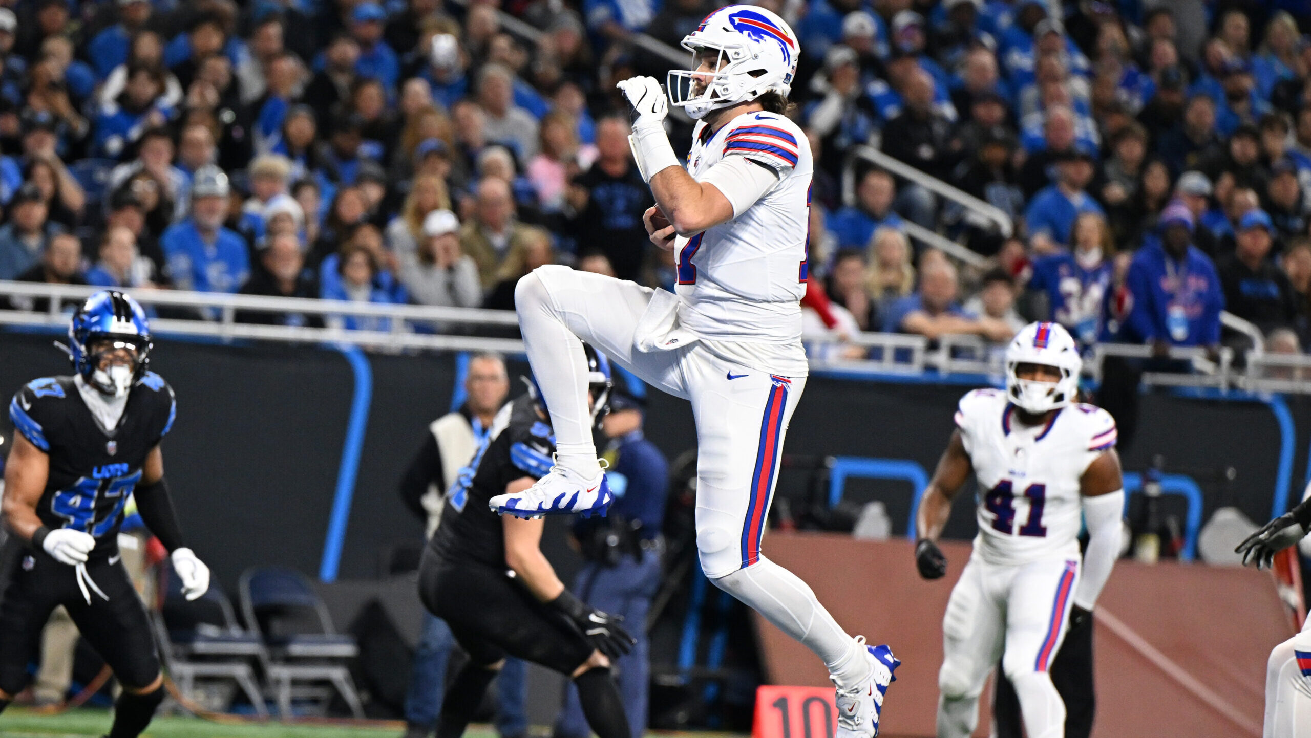 Buffalo Bills quarterback Josh Allen (17) leaps across the goal line for his second touchdown of the game against the Detroit Lions in the first quarter at Ford Field.