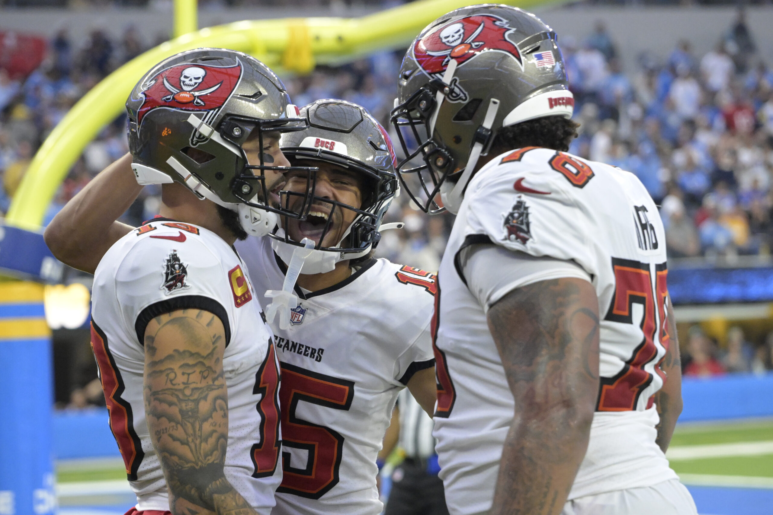 Tampa Bay Buccaneers wide receiver Mike Evans (13) is congratulated by wide receiver Jalen McMillan (15) and offensive tackle Tristan Wirfs (78) after a touchdown in the second half against the Los Angeles Chargers at SoFi Stadium.