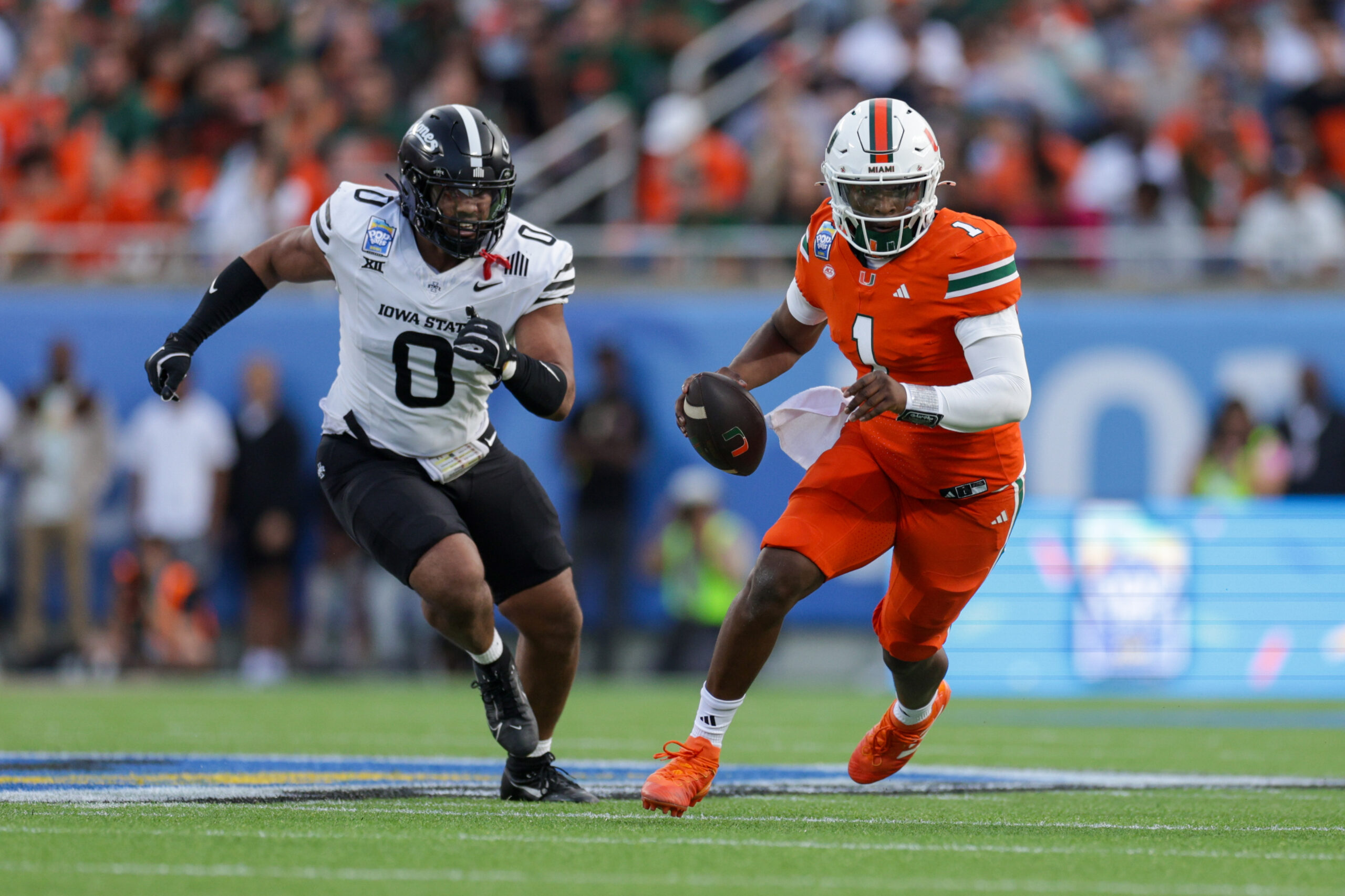 Miami Hurricanes quarterback Cam Ward (1) runs with the ball against the Iowa State Cyclones in the second quarter during the Pop Tarts bowl.