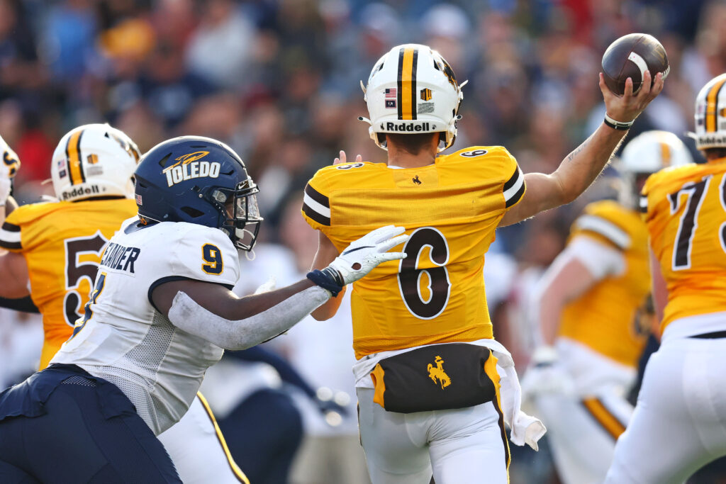 Wyoming Cowboys quarterback Andrew Peasley (6) throws a pass against Toledo Rockets defensive tackle Darius Alexander (9) during the second quarter in the Arizona Bowl. 