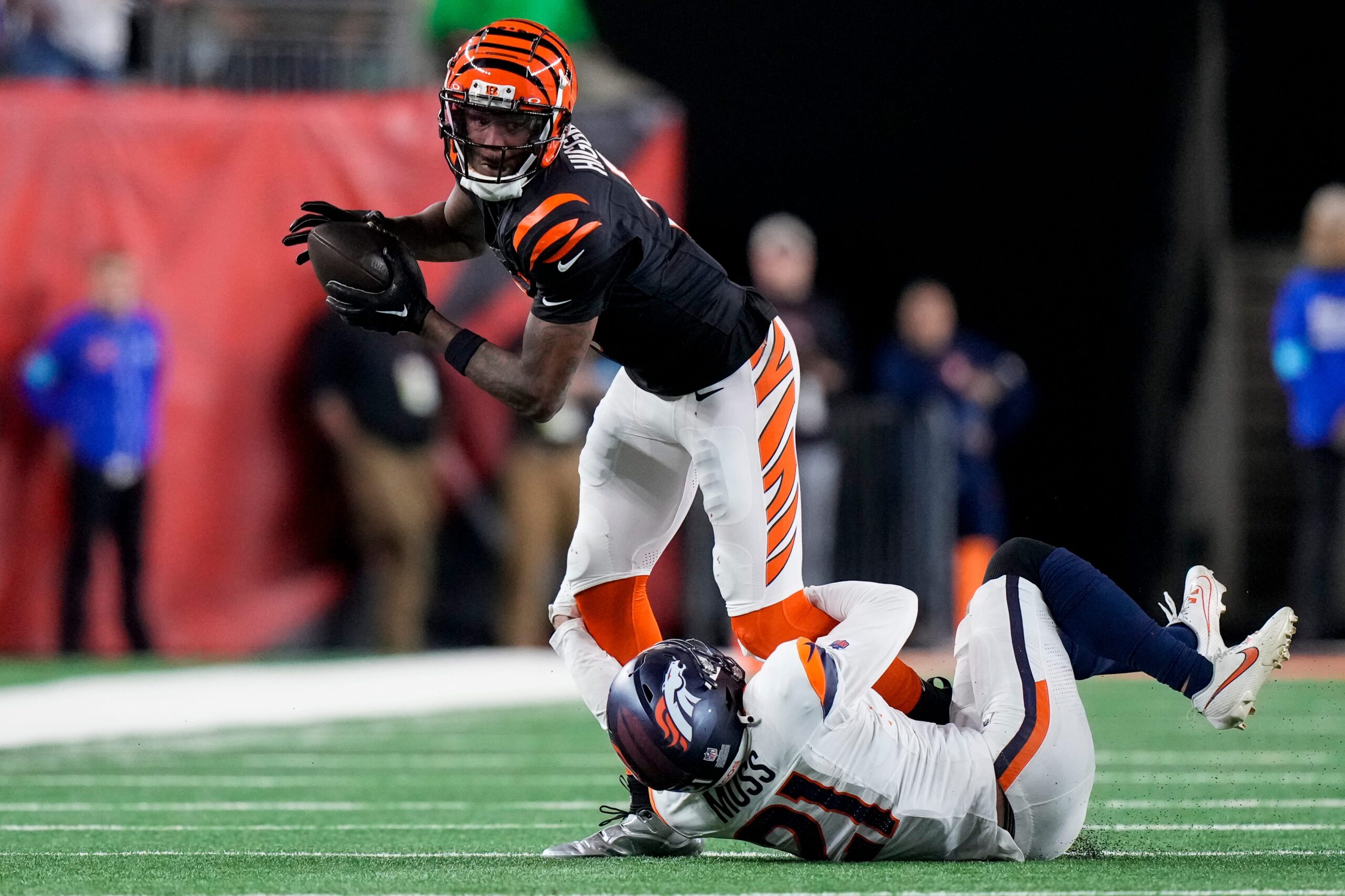 Cincinnati Bengals wide receiver Tee Higgins (5) fights a tackle from Denver Broncos cornerback Riley Moss (21) on a catch in overtime of the NFL Week 17 game between the Cincinnati Bengals and the Denver Broncos.