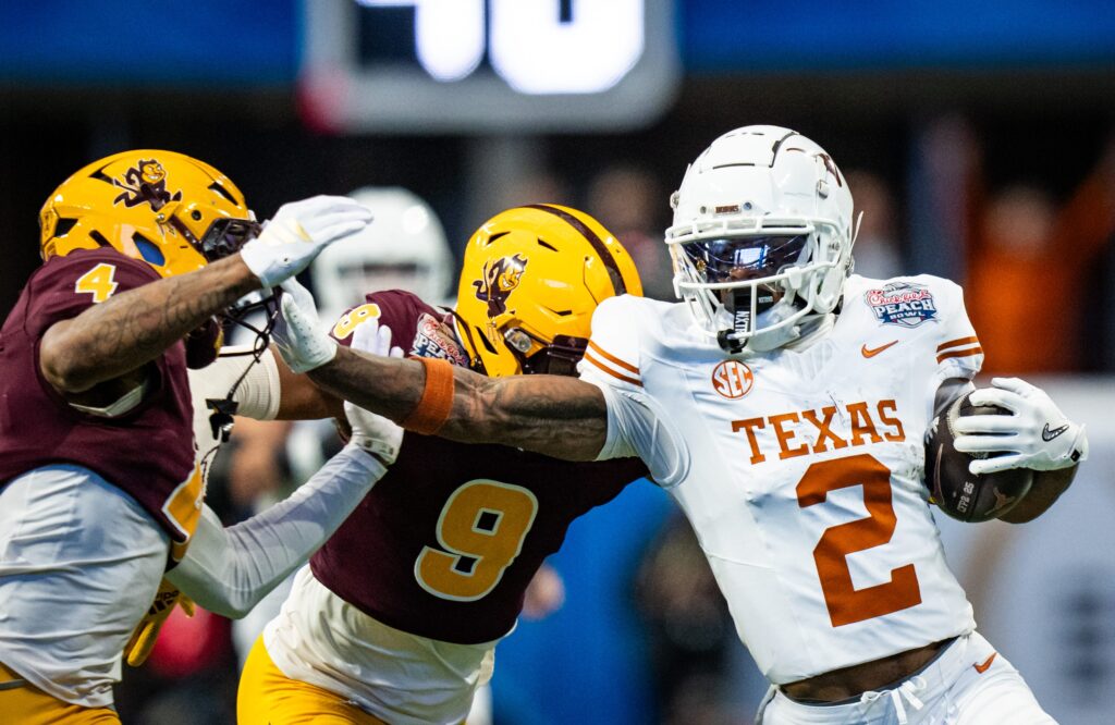 Texas Longhorns wide receiver Matthew Golden (2) grabs the facemark of Arizona State Sun Devils defensive back Myles Rowser (4) as he runs the ball in the first quarter as the Texas Longhorns play the Arizona State Sun Devils in the Peach Bowl College Football Playoff.