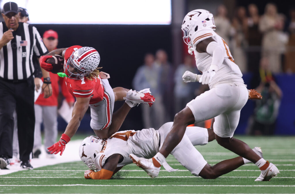 Ohio State Buckeyes running back Quinshon Judkins (1) is tackled by Texas Longhorns defensive back Andrew Mukuba (4) during the fourth quarter of the College Football Playoff semifinal.