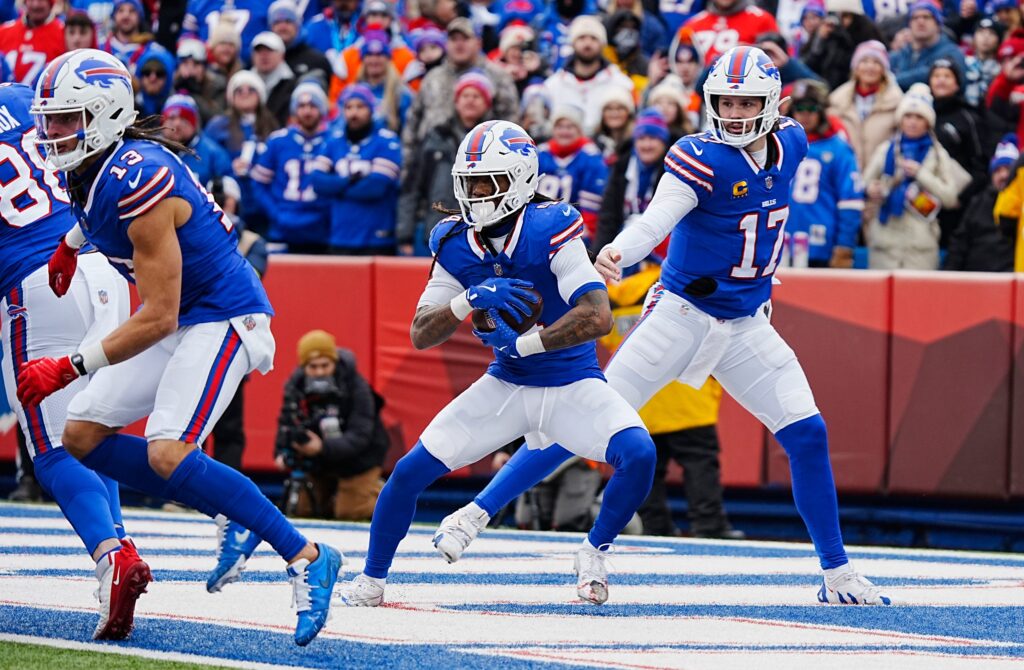 Buffalo Bills quarterback Josh Allen hands the ball off to Buffalo Bills running back James Cook during the first half of the Buffalo Bills wild card game against the Denver Broncos at Highmark Stadium.