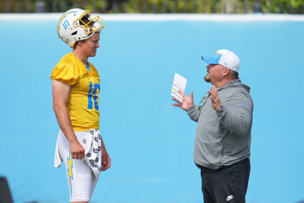 Los Angeles Chargers quarterback Justin Herbert (10) interacts with offensive coordinator Greg Roman during minicamp at the Hoag Performance Center.