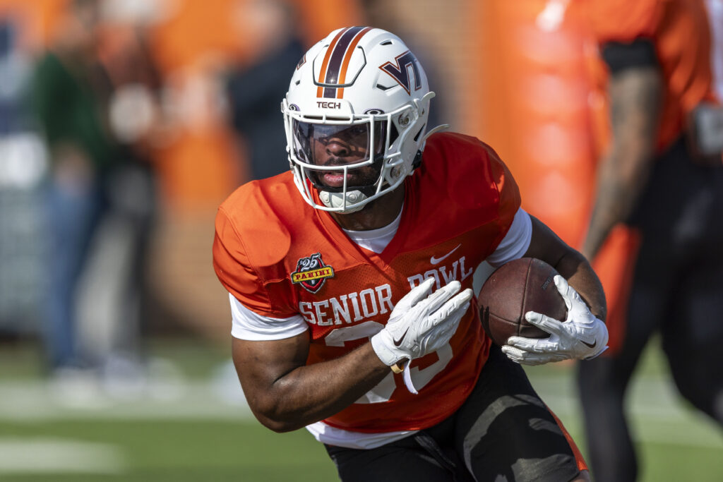 National team running back Bhayshul Tuten of Virginia Tech (33) runs the ball during Senior Bowl practice for the National team at Hancock Whitney Stadium.