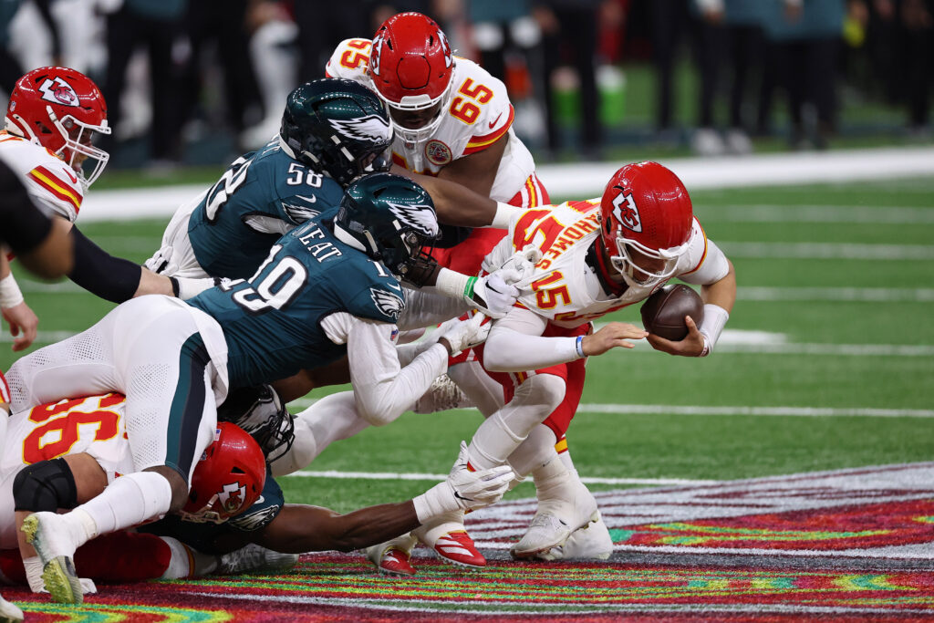 Philadelphia Eagles linebacker Jalyx Hunt (58) and linebacker Josh Sweat (19) tackle Kansas City Chiefs quarterback Patrick Mahomes (15) during the first half of Super Bowl LIX at Caesars Superdome.